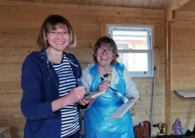 Ladies with paint brushes inside a timber lodge