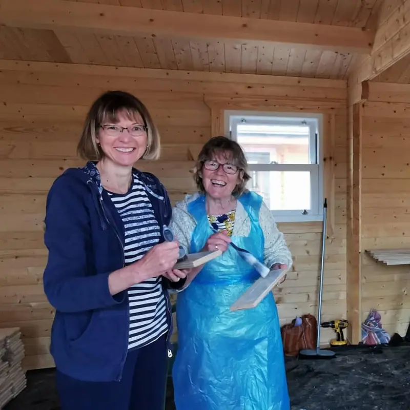 Ladies with paint brushes inside a timber lodge