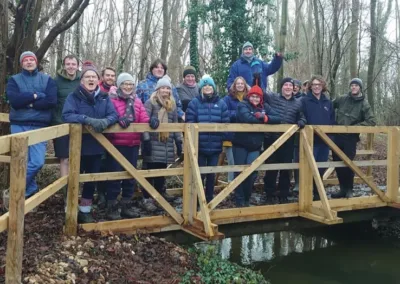 Group of people in winter outdoor kit standing on a bridge