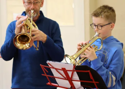 Man and child playing brass instruments