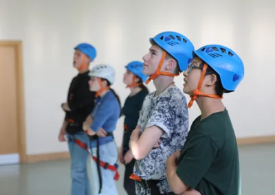 Teens with climbing helmets at the indoor climbing wall