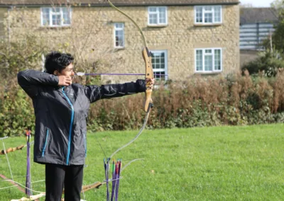 A young person aiming at a target in archery