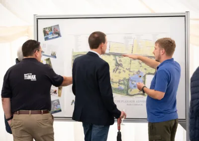 3 people looking at plans for Adventure Base