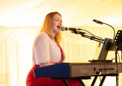 Lady singing while playing the keyboard